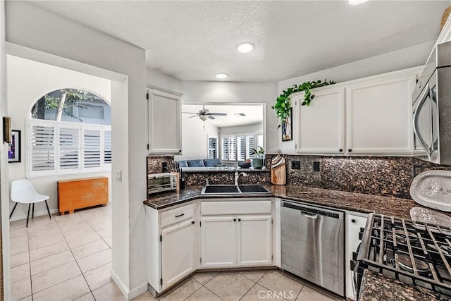 kitchen featuring stainless steel appliances, sink, light tile patterned floors, and white cabinets