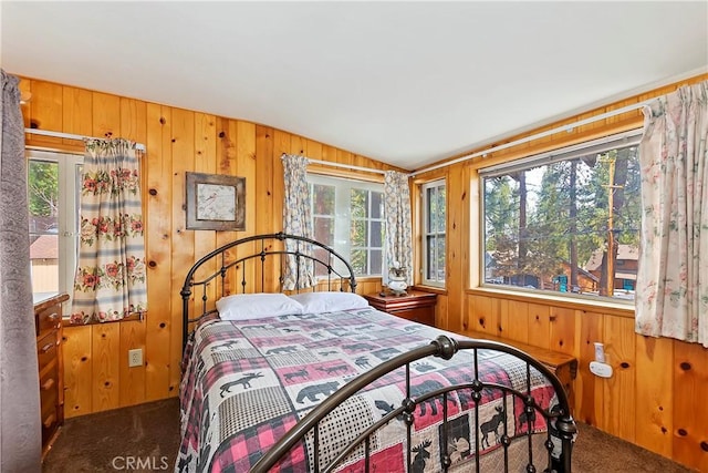 carpeted bedroom featuring multiple windows, lofted ceiling, and wood walls