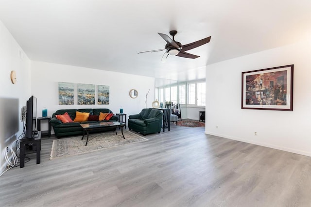 living room with light hardwood / wood-style flooring and ceiling fan