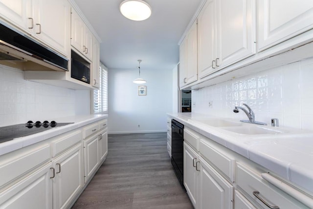 kitchen featuring white cabinetry, hanging light fixtures, and black appliances