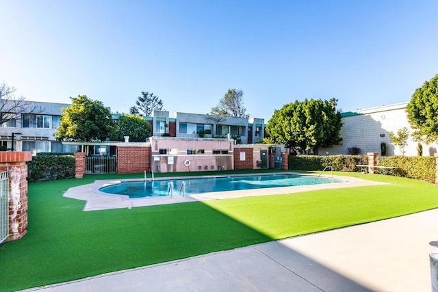 view of pool with a yard