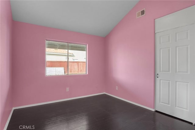 unfurnished room with vaulted ceiling and dark hardwood / wood-style floors