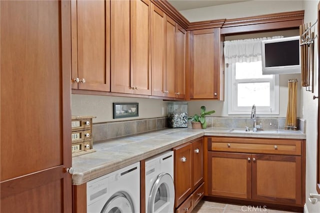 kitchen with washing machine and clothes dryer, sink, and light tile patterned floors