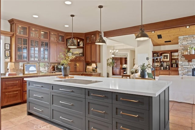 kitchen with gray cabinets, hanging light fixtures, black electric cooktop, a center island, and beam ceiling