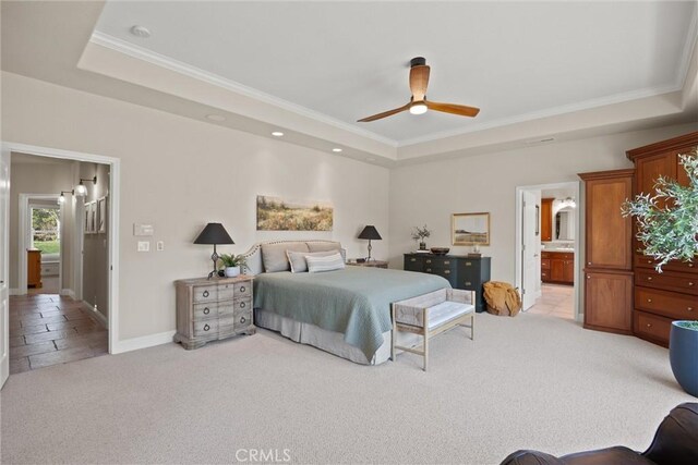 bedroom with ceiling fan, a tray ceiling, connected bathroom, and light carpet