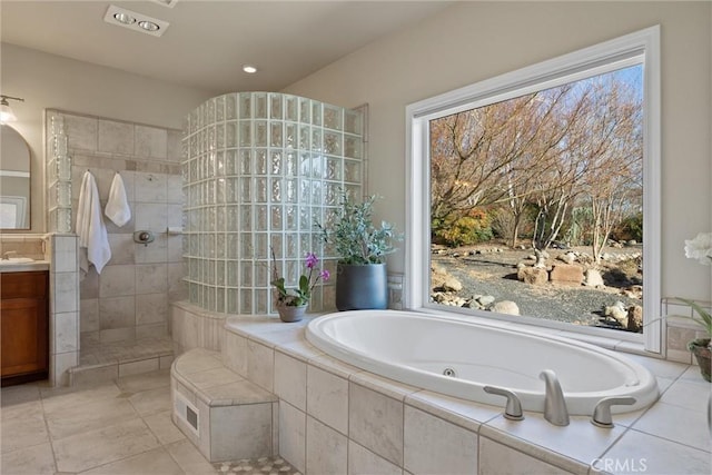 bathroom featuring vanity, a wealth of natural light, and plus walk in shower