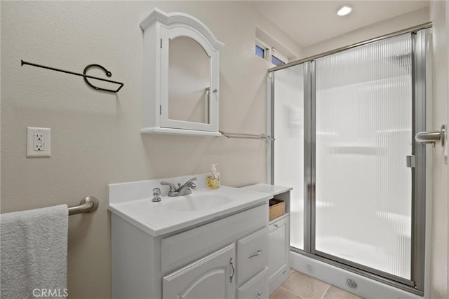 bathroom featuring tile patterned floors, vanity, and a shower with shower door