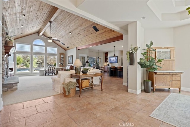 carpeted living room with a stone fireplace, wood ceiling, high vaulted ceiling, ceiling fan, and beam ceiling