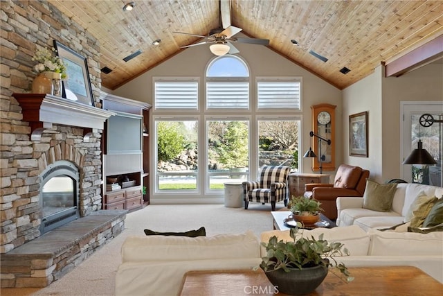 living room with a high ceiling, a stone fireplace, light colored carpet, and wood ceiling