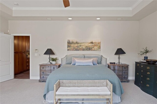 bedroom featuring ornamental molding, carpet floors, ceiling fan, and a tray ceiling