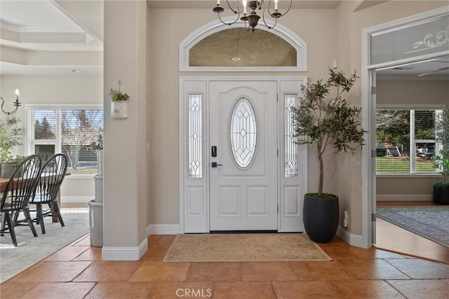 entrance foyer featuring ornamental molding and a chandelier