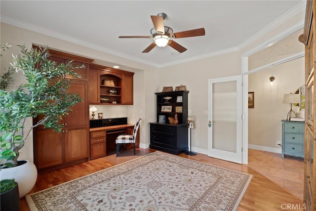 office featuring crown molding, built in desk, and light hardwood / wood-style flooring