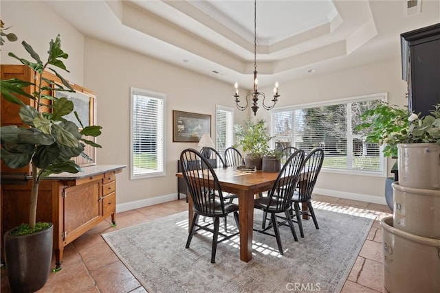 dining area with crown molding, a raised ceiling, and a notable chandelier