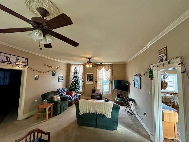 living room featuring ceiling fan, ornamental molding, a healthy amount of sunlight, and carpet