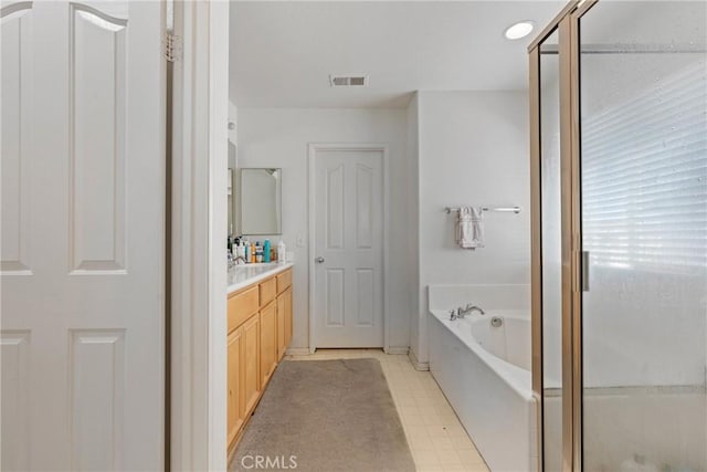 bathroom featuring tile patterned floors, vanity, and separate shower and tub