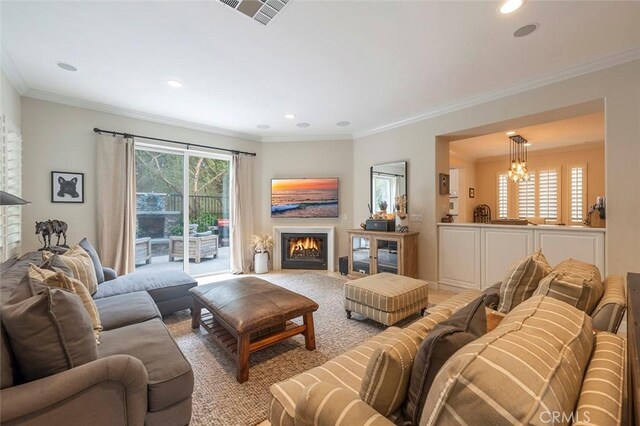 carpeted living room featuring ornamental molding and a chandelier