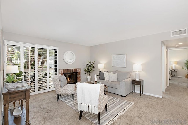 living room featuring a fireplace and light carpet