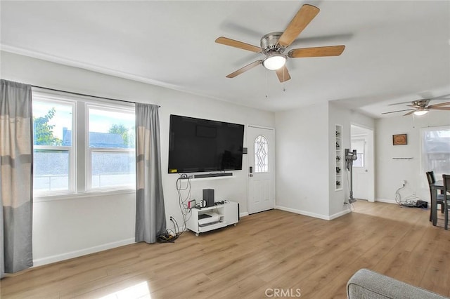 living room with ceiling fan and light wood-type flooring