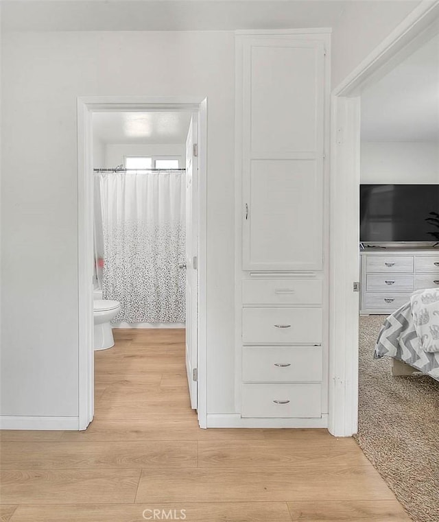 bathroom with wood-type flooring, toilet, and walk in shower