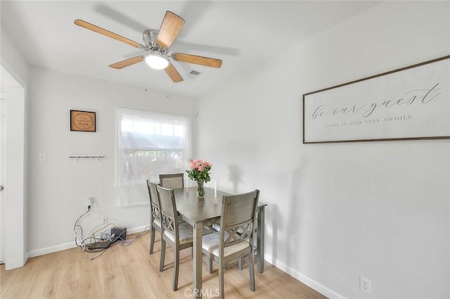 dining room with ceiling fan and light hardwood / wood-style floors