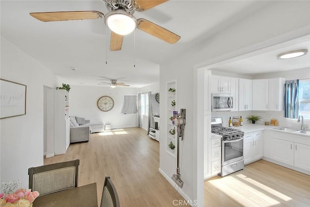 kitchen featuring white cabinetry, appliances with stainless steel finishes, sink, and light hardwood / wood-style floors