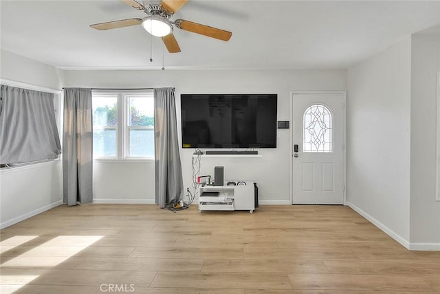 foyer entrance with ceiling fan, a healthy amount of sunlight, and light wood-type flooring