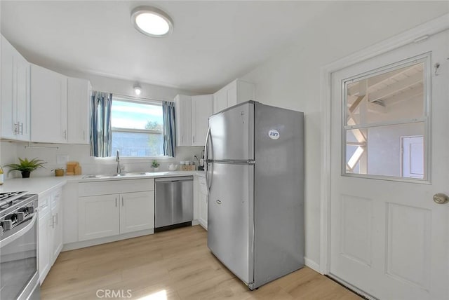 kitchen featuring white cabinetry, appliances with stainless steel finishes, light hardwood / wood-style floors, and sink