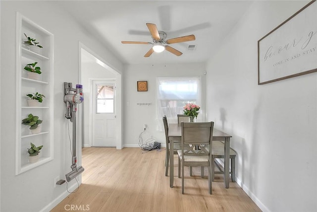 dining area featuring built in features, light hardwood / wood-style floors, and ceiling fan