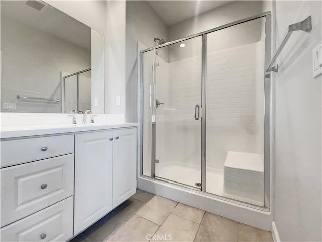 bathroom with tile patterned flooring, vanity, and a shower with door