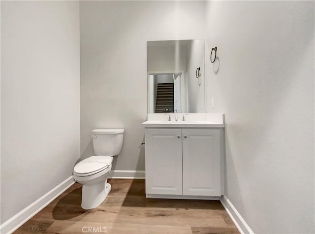 bathroom featuring vanity, wood-type flooring, and toilet