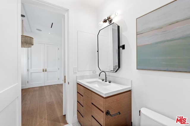 bathroom with vanity, hardwood / wood-style flooring, and toilet