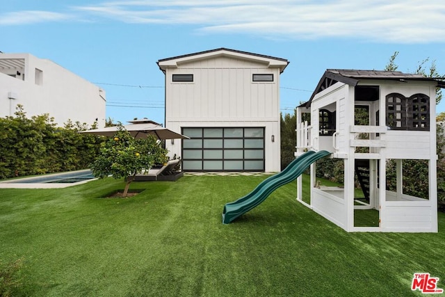 rear view of house with a lawn and a playground