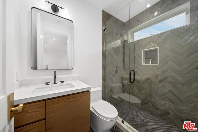 bathroom featuring vanity, a shower with shower door, and toilet