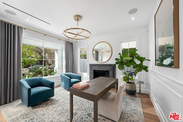 interior space featuring an inviting chandelier, a high end fireplace, and wood-type flooring