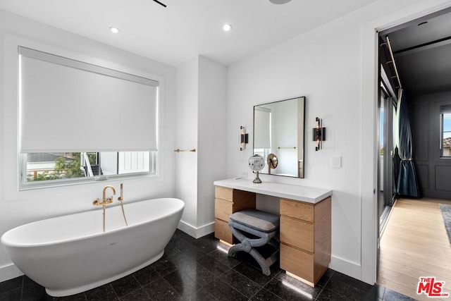 bathroom with vanity and a bath