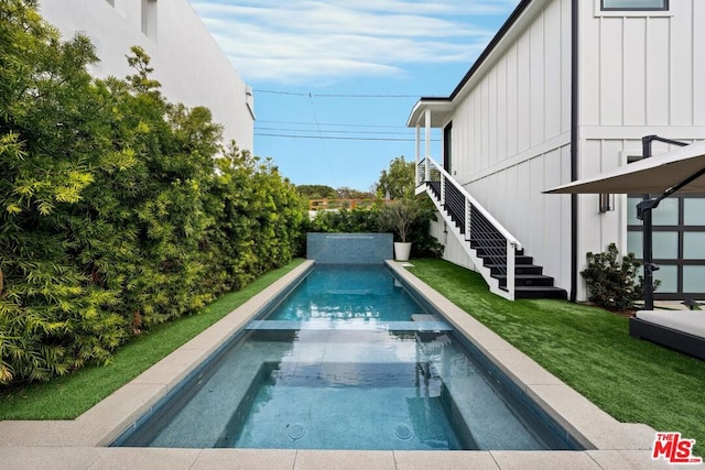 view of swimming pool featuring a lawn