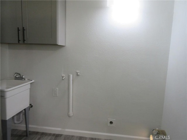 laundry area with cabinets, dark hardwood / wood-style flooring, and electric dryer hookup