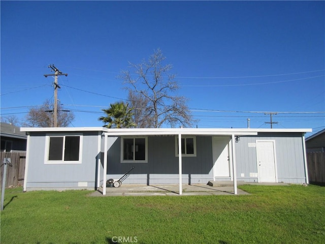 rear view of property featuring a lawn