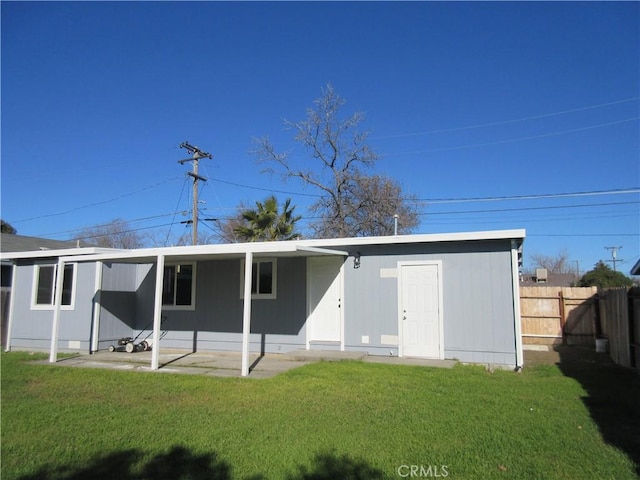 rear view of house featuring a yard and a patio area