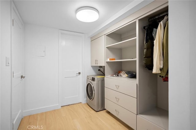 washroom with washer / clothes dryer, cabinets, and light hardwood / wood-style floors