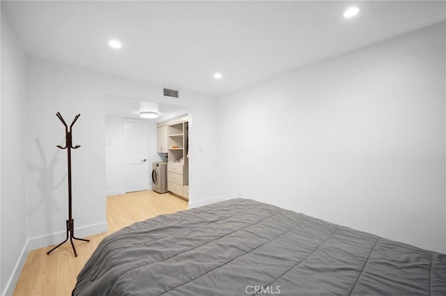 bedroom featuring washer and dryer and light hardwood / wood-style flooring