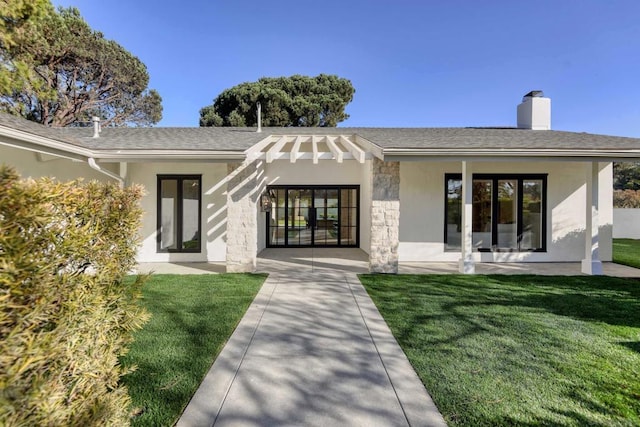 rear view of property featuring a lawn and a patio