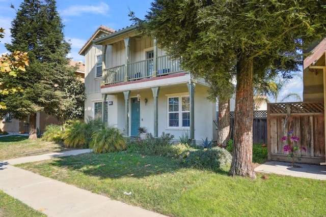 view of front facade with a balcony and a front lawn