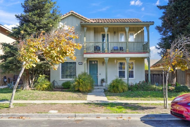 view of front of home featuring a balcony and a front lawn