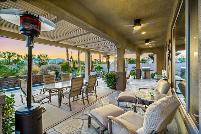 patio terrace at dusk featuring area for grilling and a pergola