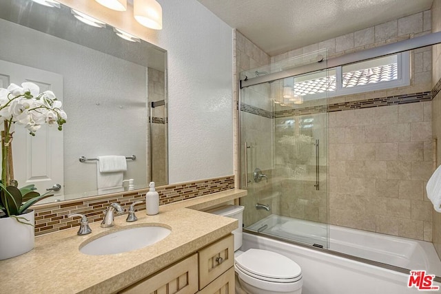 full bathroom with toilet, shower / bath combination with glass door, a textured ceiling, vanity, and decorative backsplash