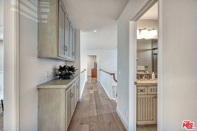 hallway with sink and light wood-type flooring