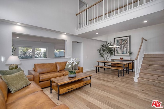 living room featuring a towering ceiling and light wood-type flooring