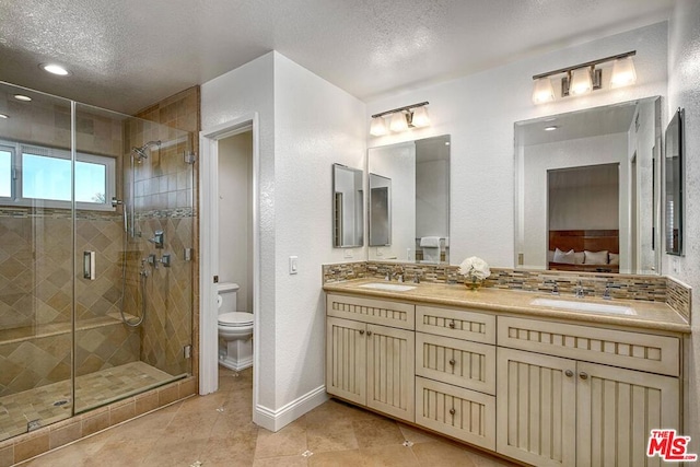 bathroom with tasteful backsplash, vanity, walk in shower, toilet, and a textured ceiling