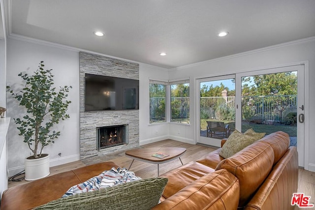 living room featuring a fireplace, ornamental molding, and light wood-type flooring